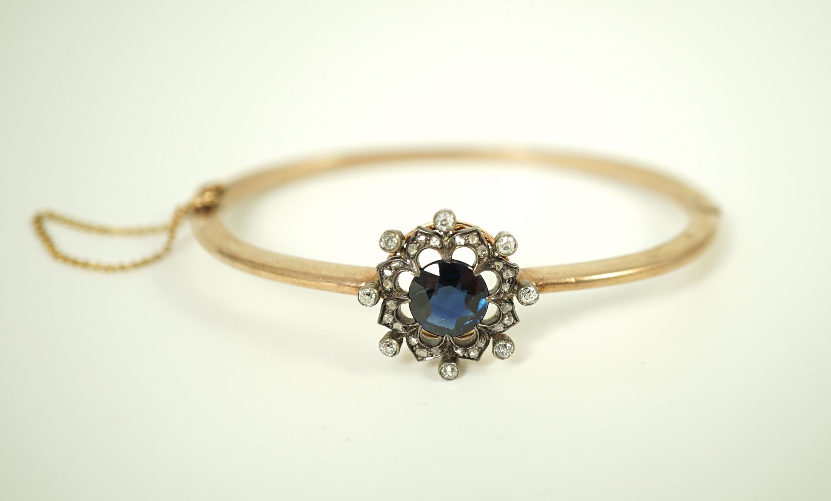A Victorian gold, sapphire and diamond cluster set hinged bangle